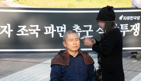 비장  황교안 자유한국당 대표가 16일 청와대 앞 분수대 광장에서 '조국 법무부장관 파면 촉구' 삭발식을 하고 있다.   이슬기기자 9904sul@